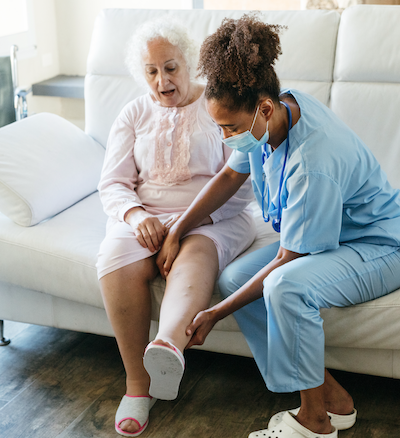 Nurse providing physical therapy for patient at home