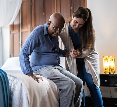 Nurse helping hospice patient out of bed