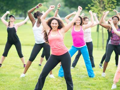 Un grupo de mujeres en una clase de ejercicio al aire libre.