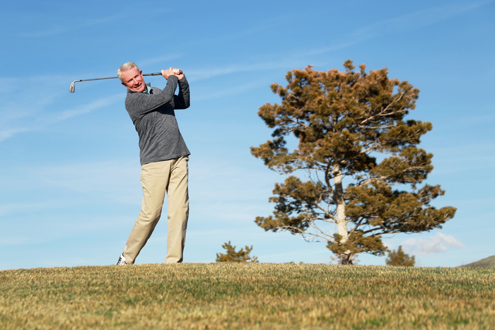 hombre disfruta jugando al golf después de un reemplazo articular