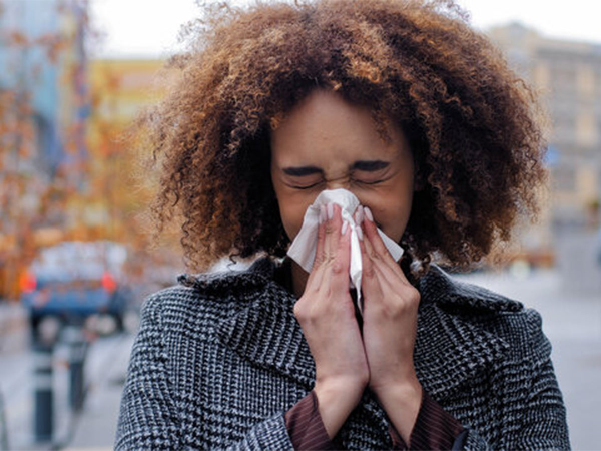 young woman with seasonal allergies sneezes