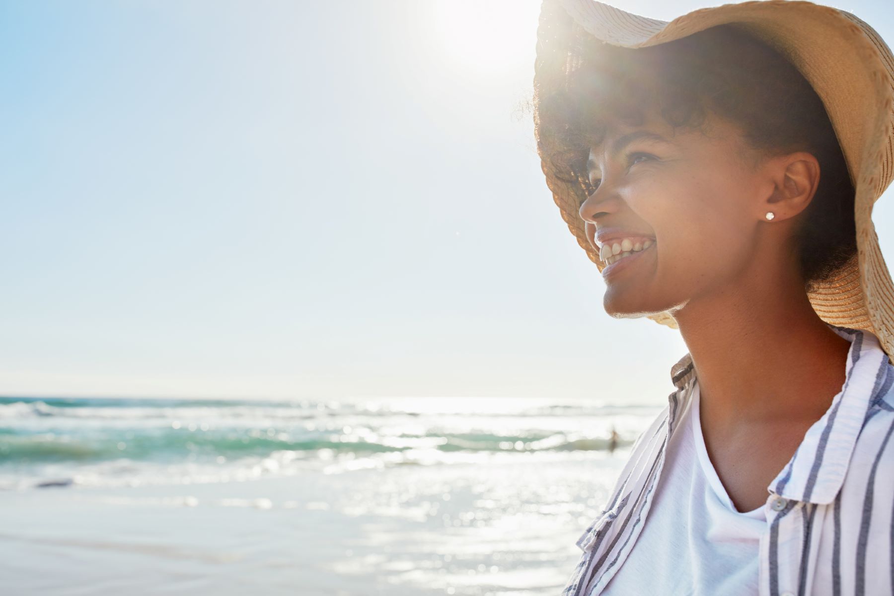 mujer al sol con sombrero para evitar el cáncer de piel