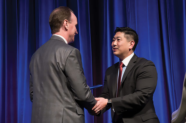 Christopher Holden, CEO/President of Envision Healthcare, presents the award to Dr. Rhee.
